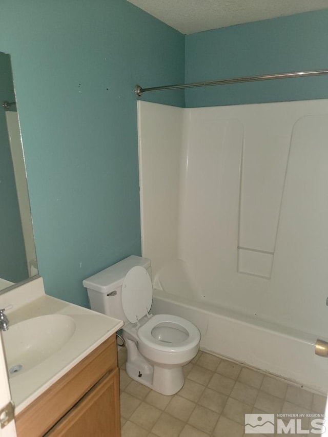 full bathroom with tile patterned floors, vanity, toilet, and a textured ceiling