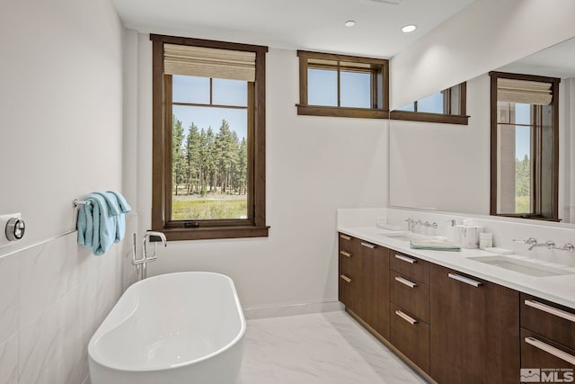 bathroom featuring vanity, a bathtub, and tile walls