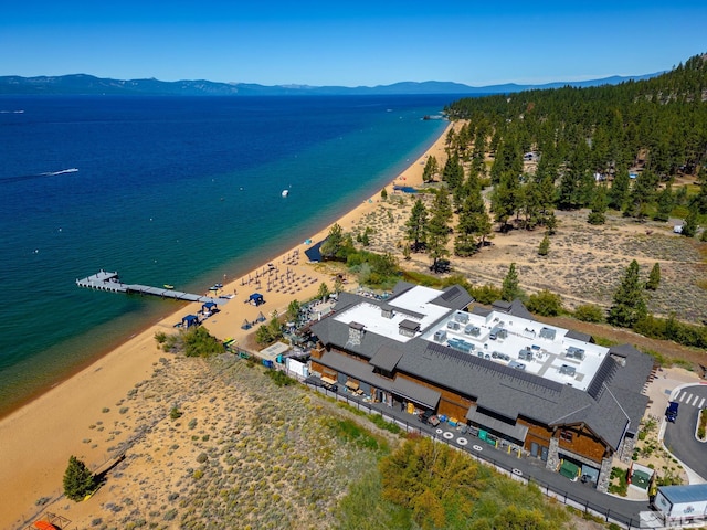 drone / aerial view with a water and mountain view and a view of the beach