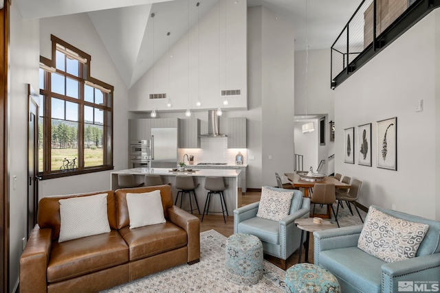 living room featuring light hardwood / wood-style floors and high vaulted ceiling