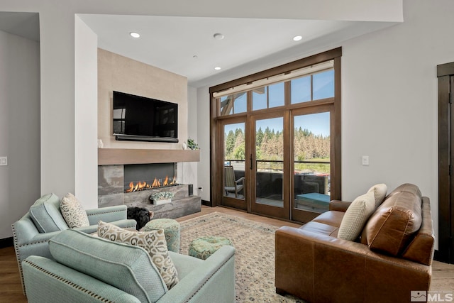 living room featuring a high end fireplace and hardwood / wood-style flooring