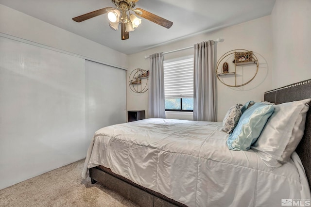 carpeted bedroom featuring ceiling fan and a closet