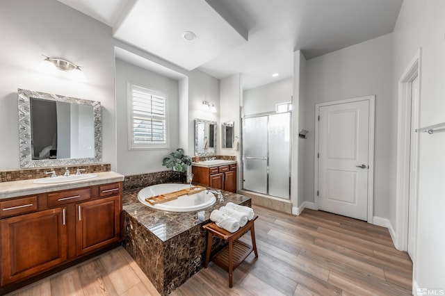 bathroom with hardwood / wood-style floors, vanity, and shower with separate bathtub