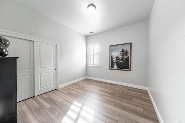 unfurnished bedroom with a closet and light hardwood / wood-style floors