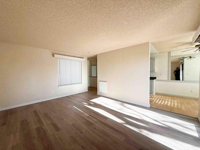 empty room featuring ceiling fan, hardwood / wood-style floors, and a textured ceiling