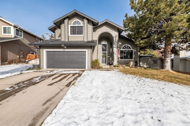 view of front facade with concrete driveway, fence, and an attached garage