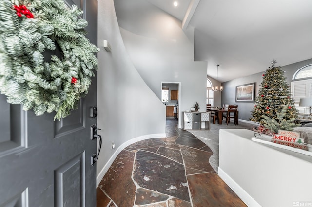 foyer featuring high vaulted ceiling and an inviting chandelier