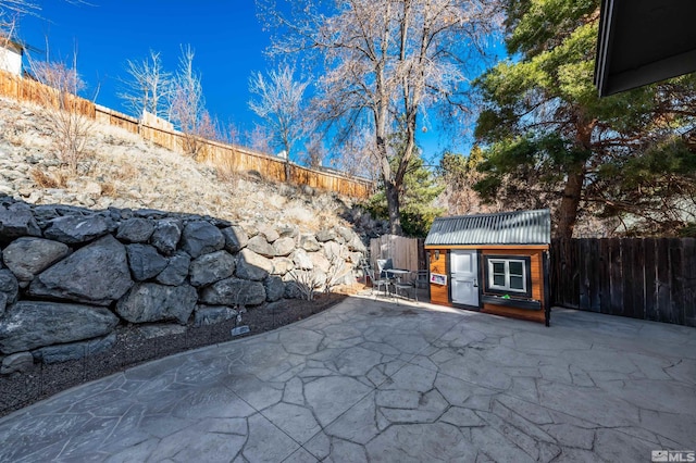 view of patio with a fenced backyard and an outbuilding