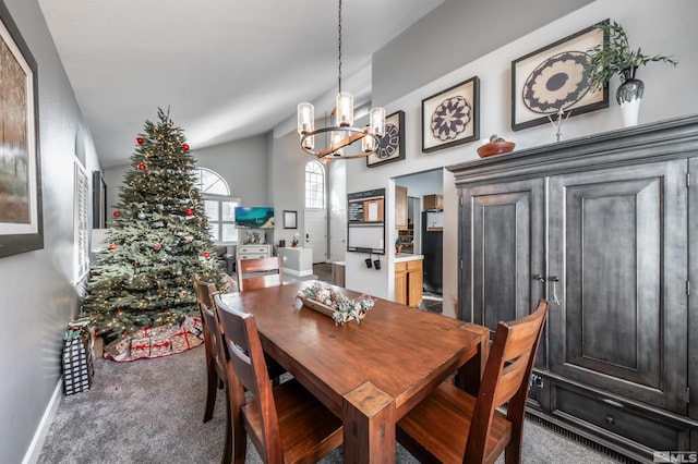 carpeted dining area with a chandelier and baseboards