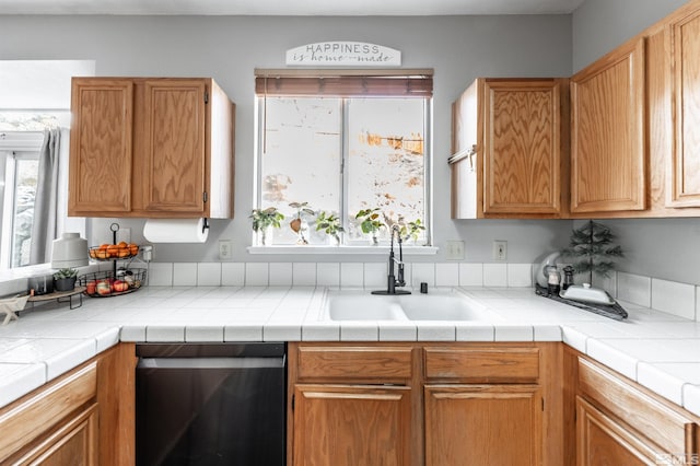 kitchen with a sink, light countertops, and dishwasher