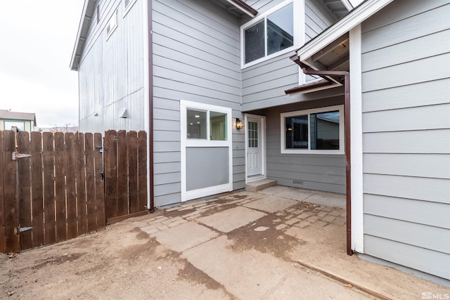 view of exterior entry with a patio area