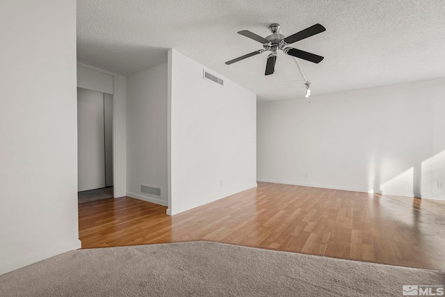 spare room featuring wood-type flooring, a textured ceiling, and ceiling fan