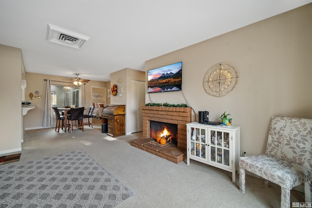 living room featuring carpet flooring, ceiling fan, and a fireplace