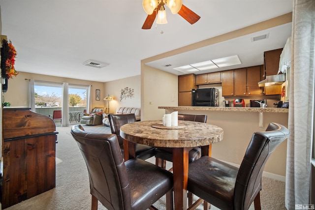 carpeted dining area featuring ceiling fan