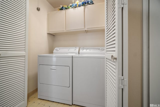 washroom with cabinets and washing machine and dryer