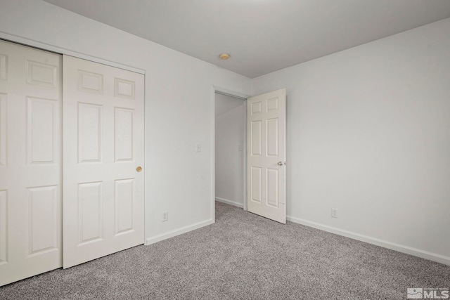 unfurnished bedroom with carpet flooring and a closet