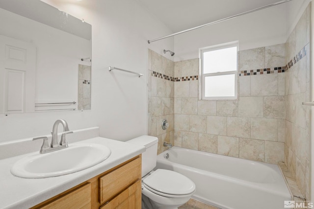 full bathroom with vanity, tiled shower / bath, and toilet