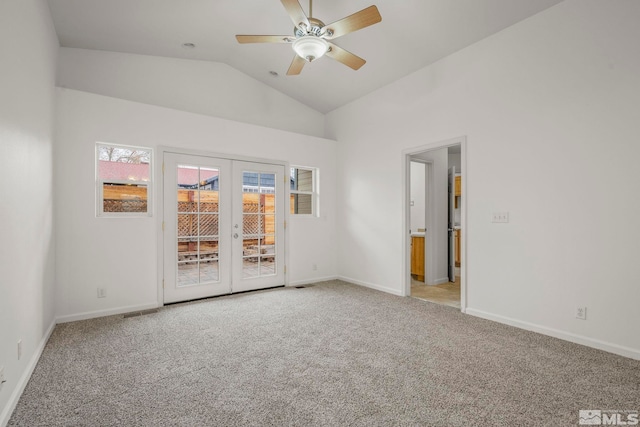 carpeted spare room with ceiling fan, lofted ceiling, and french doors