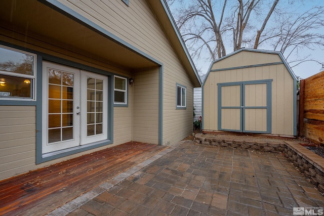 view of patio featuring a shed, a wooden deck, and french doors