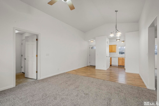 unfurnished living room featuring ceiling fan with notable chandelier, light wood-type flooring, and lofted ceiling