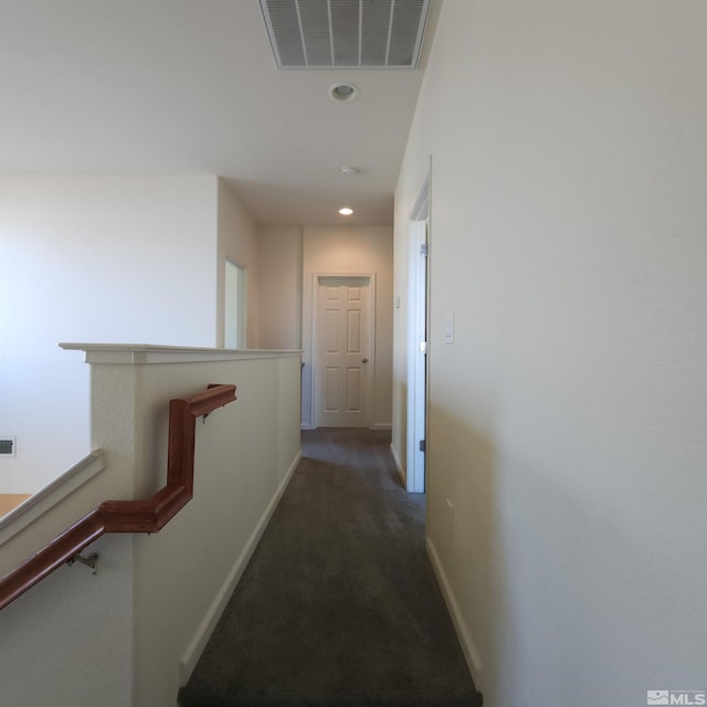 corridor featuring dark colored carpet