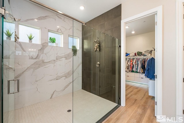 bathroom with wood-type flooring and an enclosed shower