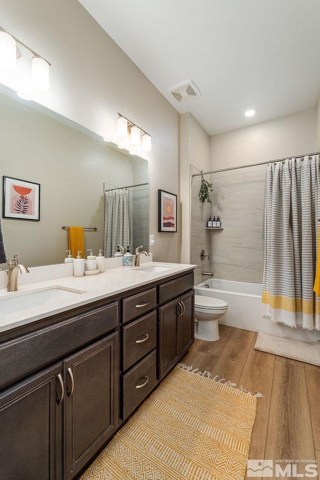 full bathroom with wood-type flooring, vanity, toilet, and shower / bath combo with shower curtain