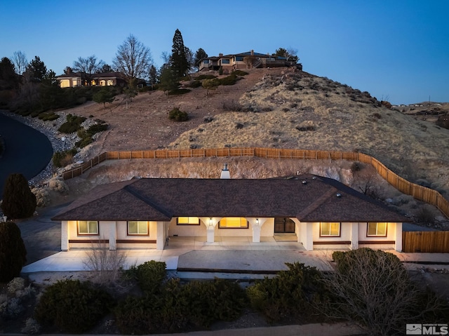 back house at dusk with a patio area