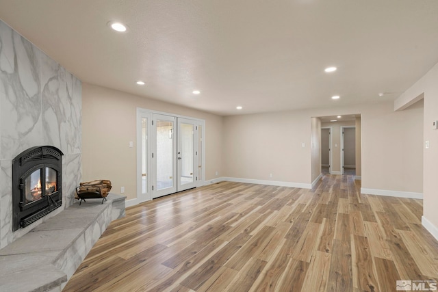 unfurnished living room featuring a large fireplace and light hardwood / wood-style flooring