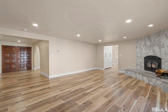 unfurnished living room with light wood-type flooring and a large fireplace