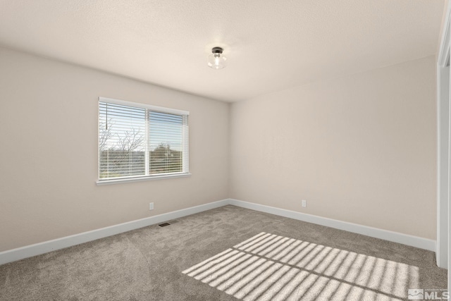 carpeted spare room featuring a textured ceiling