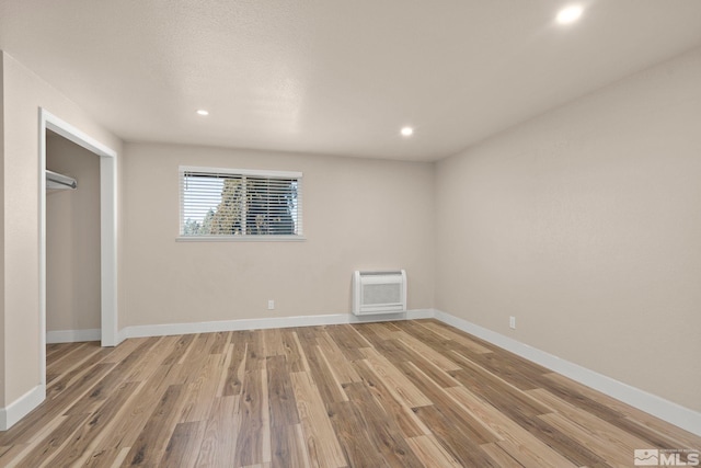 empty room featuring light hardwood / wood-style floors and heating unit