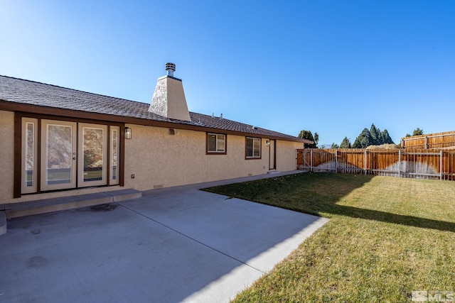 back of house with a lawn and a patio area