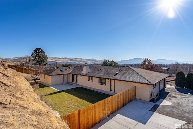 view of front of property featuring a mountain view, a patio, and a front yard