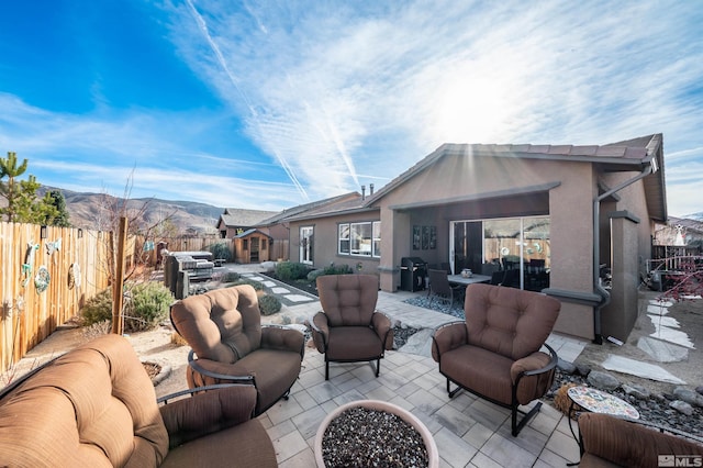 view of patio featuring a mountain view, area for grilling, and an outdoor living space with a fire pit