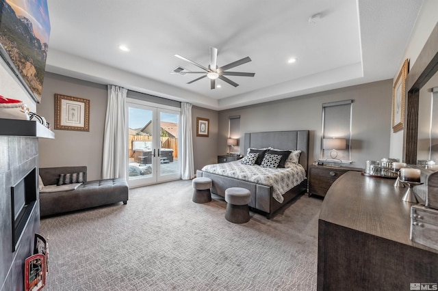 bedroom with access to exterior, carpet, french doors, a tray ceiling, and ceiling fan