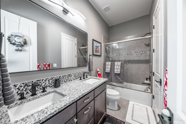 full bathroom featuring tile patterned floors, vanity, bath / shower combo with glass door, and toilet