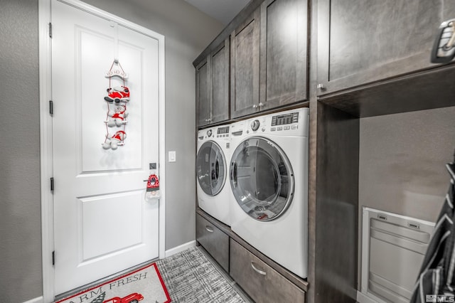 clothes washing area with cabinets and separate washer and dryer