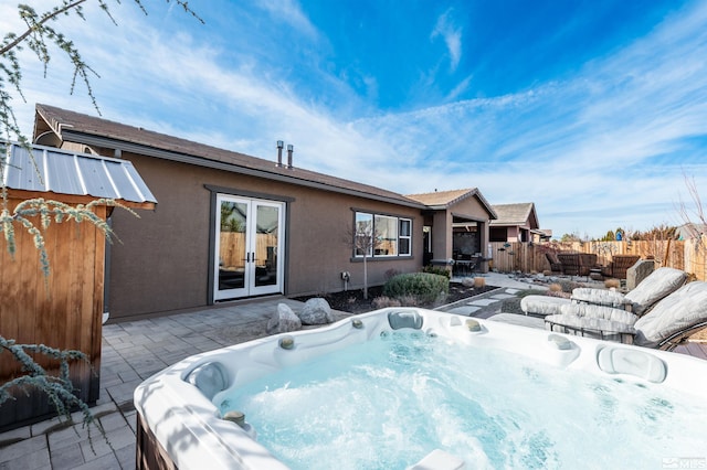 rear view of house with french doors, a patio, and a hot tub