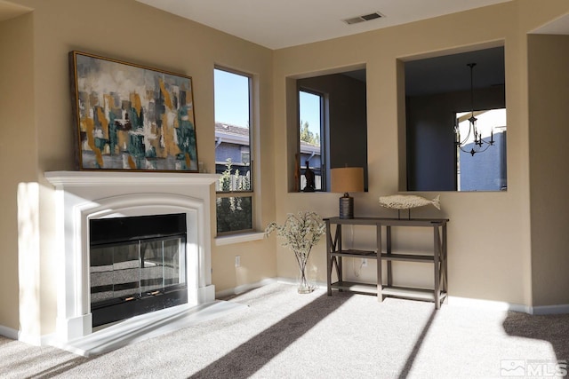 living area featuring carpet and a chandelier