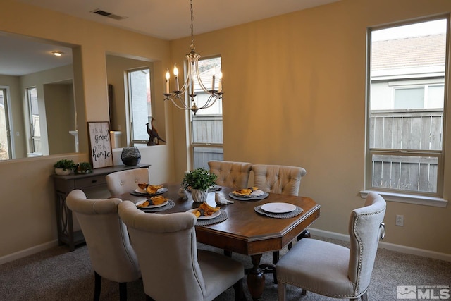 dining room featuring carpet and a notable chandelier