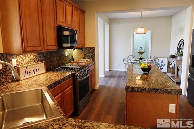 kitchen with sink, decorative light fixtures, stainless steel appliances, dark hardwood / wood-style flooring, and tasteful backsplash