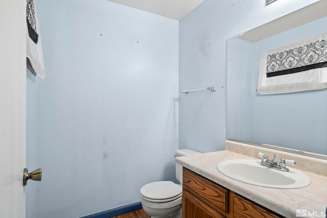 bathroom featuring hardwood / wood-style flooring, vanity, and toilet