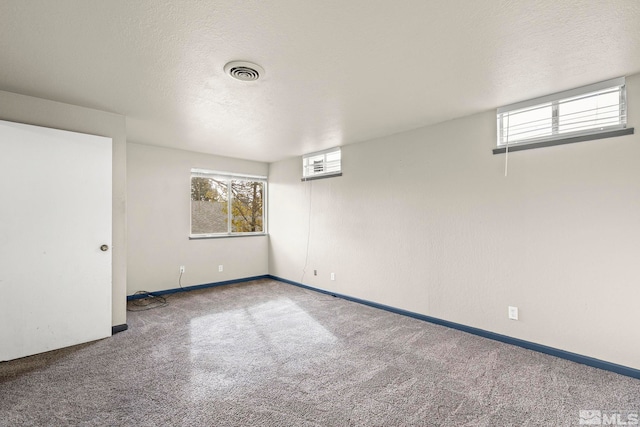 spare room with a textured ceiling and carpet floors