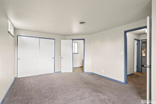 unfurnished bedroom with light carpet, a closet, and a textured ceiling