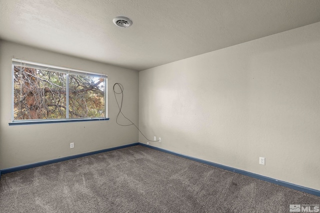 carpeted empty room with a textured ceiling