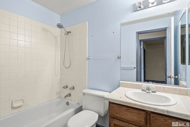 full bathroom with vanity, tiled shower / bath combo, and toilet