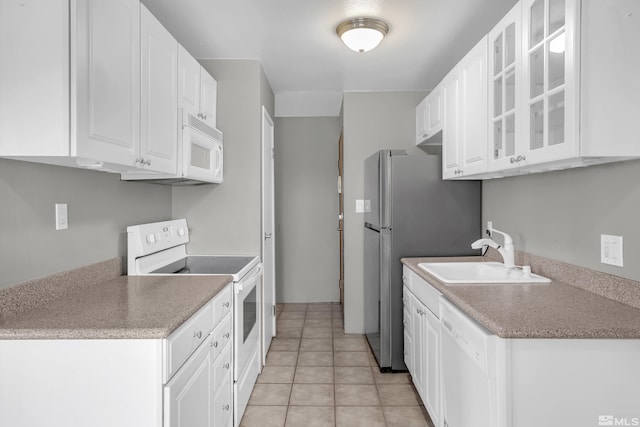 kitchen with sink, white cabinets, white appliances, and light tile patterned floors