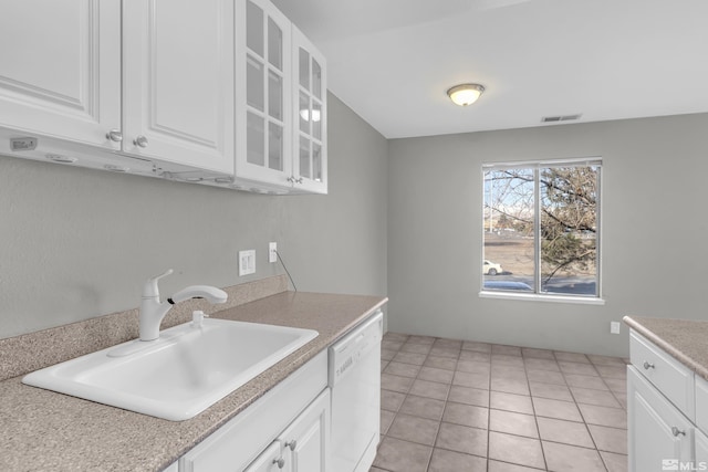 kitchen with white cabinets, white dishwasher, light tile patterned flooring, and sink