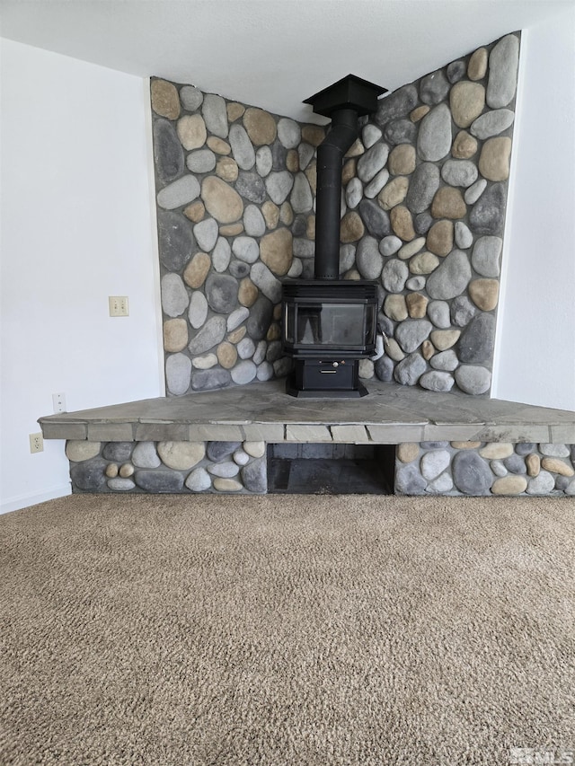 room details featuring carpet floors and a wood stove